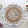 Beautiful round woven table mat with lace detail and pom-pom edges